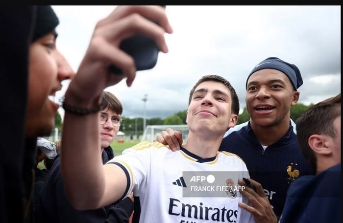 Kylian Mbappe berpose dengan fan Real Madrid pada momen latihan timnas Prancis di Clairefontaine (30/5/2024).